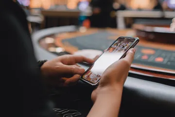 Altın paralarla çevrili slot makinesinde kazanan yedililer, büyük kazançları simgeler.