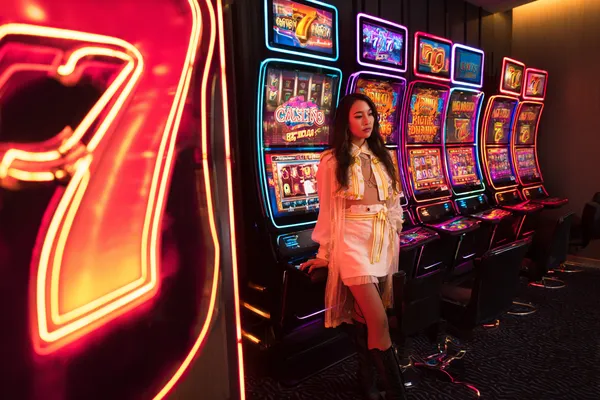 Casino fişleriyle çevrili kendinden emin bir krupiye, oyuncuları MERIT CASINO hesaplarına giriş yapmaya davet eder.